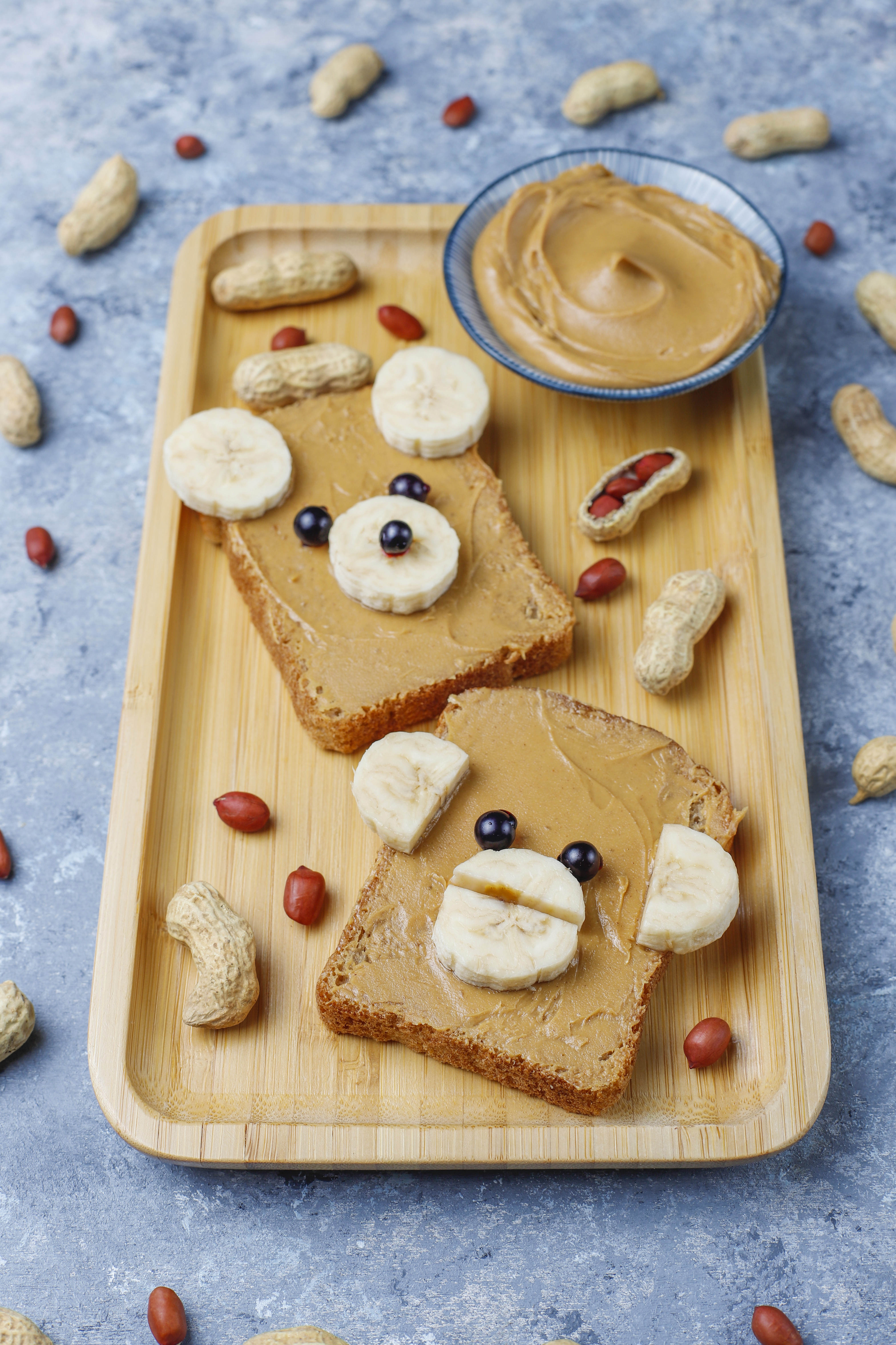 funny-bear-monkey-face-sandwich-with-peanut-butter-banana-black-currant-peanuts-top-view.jpg